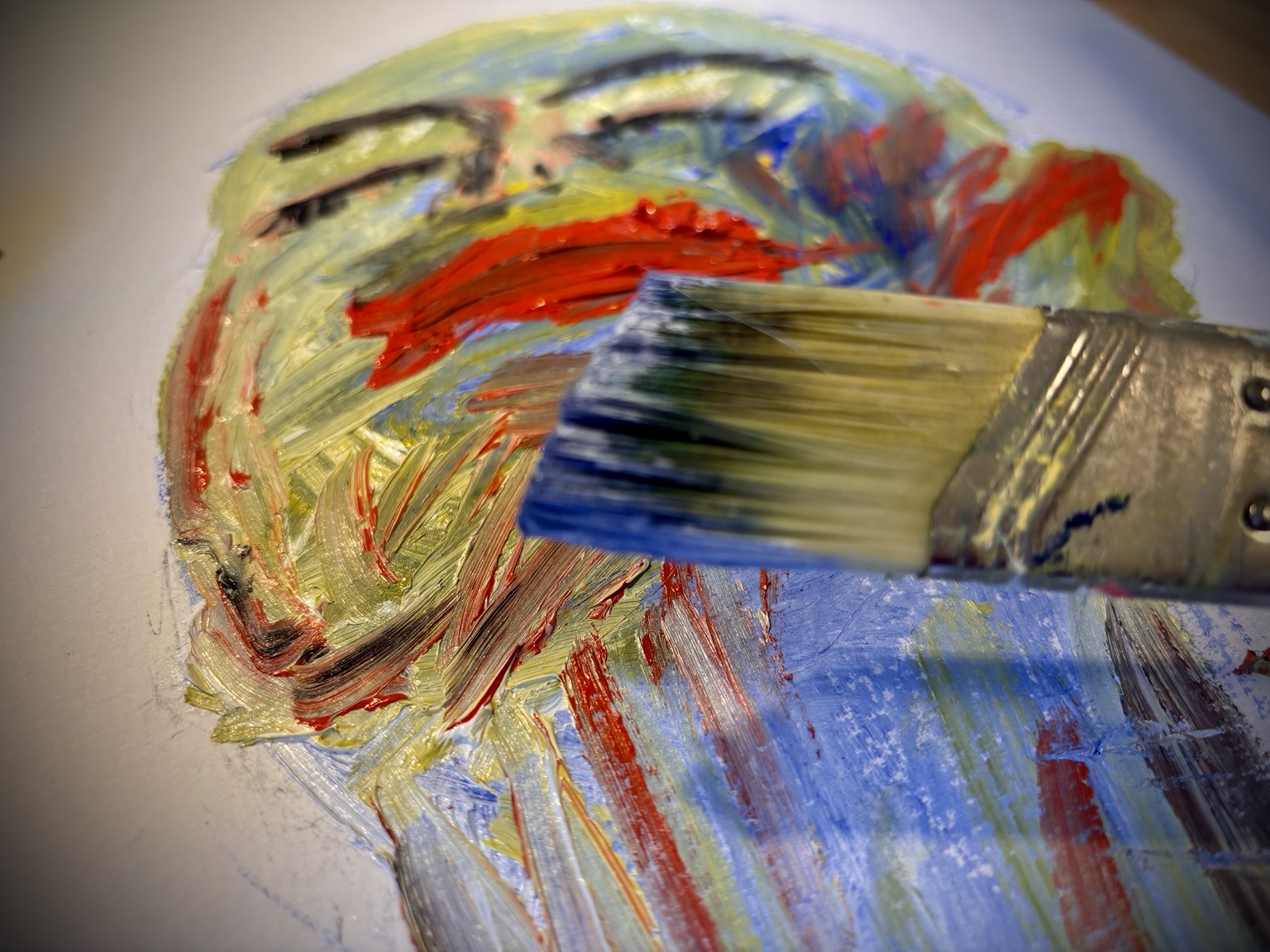 Wide brush moving paint across a portrait